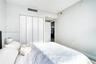 Neutral-toned room featuring a four-panel bi-fold closet with brushed metal hardware and light-toned flooring