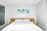 Built-in wood-finish headboard featuring integrated side shelving and neutral wall finishes