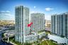 High-rise glass facade featuring wraparound balconies and a central concrete structural design