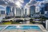 Swimming pool with a paved deck, glass railing, and prominent metropolitan skyline backdrop