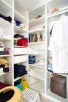 Custom walk-in closet featuring white floor-to-ceiling built-in cabinetry, adjustable open shelving, and integrated pull-out drawers