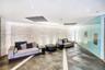 Curved stone-textured accent wall with integrated LED uplighting, large-format tile flooring with contrasting linear inlays, and floor-to-ceiling glas