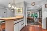 Room featuring terra cotta tile flooring, a multi-light fixture, and a built-in counter with storage