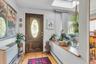 Hardwood flooring, wood-panel entry door with decorative glass inlay, overhead skylight, and half wall with wood ledge