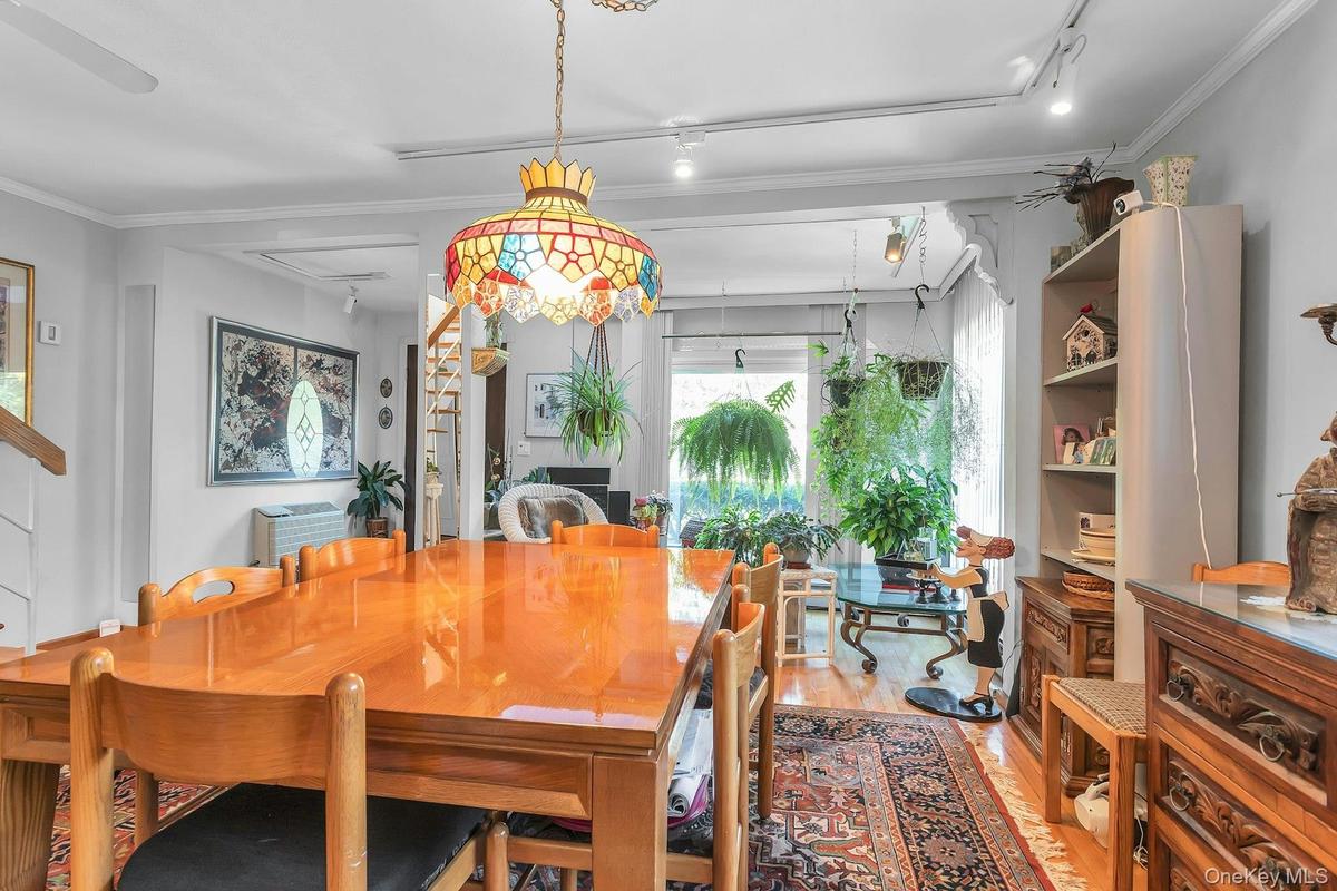 Hardwood flooring, recessed lighting, and a stained glass chandelier