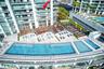 Elevated terrace balcony featuring floor-to-ceiling glass panel doors, exterior swimming pool, multi-level sundeck, and landscaped grounds