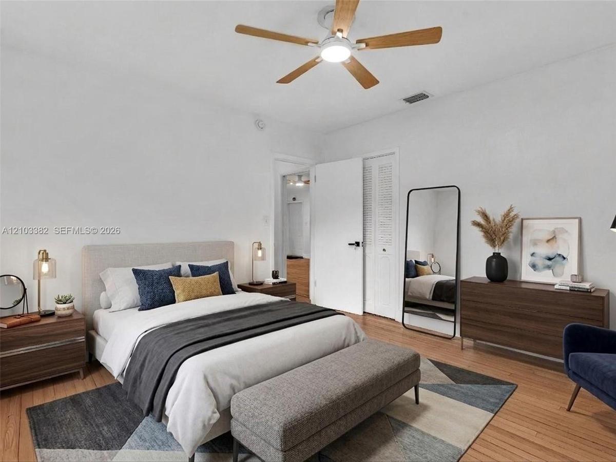 VIRTUAL STAGING. East bedroom featuring wood-finish flooring, a ceiling fan with integrated lighting, and louvered-panel closet doors. House for rent 