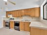 Kitchen featuring tile countertops, tile backsplash, stainless steel range, and integrated ceiling fan. House for rent in Coral Gables. House for rent