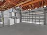 Huge 2 car, attached garage featuring a white sectional roll-up door, exposed wood joist ceiling, concrete walls, and concrete flooring. House for ren