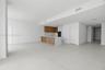 Open-concept interior featuring large-format tile flooring, wood-finish cabinetry, a waterfall-edge kitchen island, and built-in wall ovens