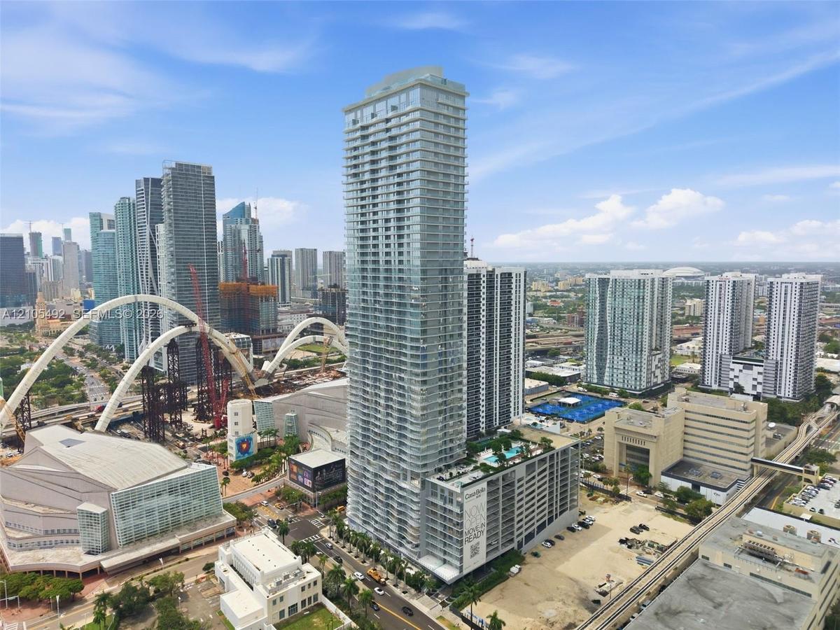 High-rise glass facade skyscraper featuring floor-to-ceiling windows, private balconies, and an elevated terrace with a swimming pool