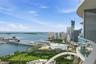 Curved balcony featuring glass railings and expansive water and urban skyline scenery