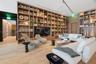 Floor-to-ceiling built-in wood shelving, integrated recessed lighting, and wood-finish flooring