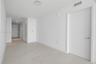 Interior space featuring large-format ceramic tile flooring, smooth white walls, solid-core interior doors with satin nickel hardware, and recessed LE