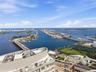 High-rise balcony featuring a glass railing and unobstructed panoramic water and urban harbor scenery