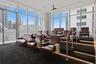 Floor-to-ceiling windows, tiered seating platform, integrated LED stair lighting, and ceiling-mounted projection hardware