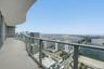Curved balcony featuring large-format tile flooring and a glass-paneled railing