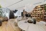 Open-concept interior featuring wood-finish flooring, a floor-to-ceiling built-in wooden bookcase, an architectural staircase with dark metal detailin