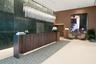 Grand lobby entrance featuring a polished stone feature wall, floor-to-ceiling wood-paneling, a custom wood-finish reception desk, and a linear tiered