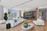 Open-concept interior featuring floor-to-ceiling windows, wood-finish flooring, linear track lighting, and built-in cabinetry with an integrated bar