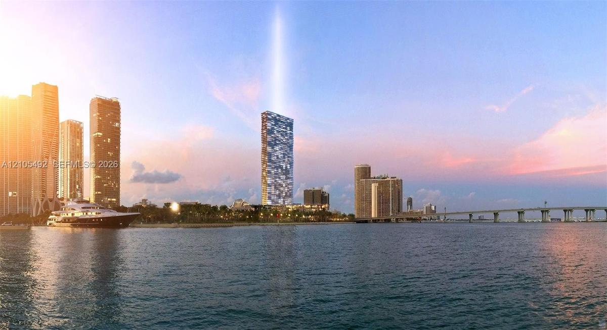 High-rise residential tower featuring a glass facade, waterfront positioning, and proximity to bridge infrastructure