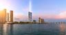 High-rise residential tower featuring a glass facade, waterfront positioning, and proximity to bridge infrastructure