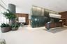 Lobby featuring stone wall cladding, wood-finish wall paneling, built-in reception desk, polished flooring, and tiered glass pendant lighting