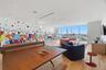 Floor-to-ceiling windows, wood-finish flooring, recessed lighting, and mural-accented wall