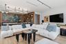 Open-concept living space featuring wood-finish flooring, floor-to-ceiling built-in wood shelving, an industrial-style linear light fixture, and reces