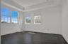 Room featuring dark tile flooring, a tray ceiling, and windows with arched upper panes
