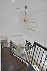 Staircase featuring dark wood-finish treads and a decorative metal railing, highlighted by a multi-point sputnik-style chandelier, recessed lighting, 