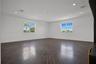 Expansive living area featuring wood-finish flooring, recessed lighting, crown molding, and large grid-patterned windows