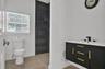 Bathroom featuring a floating vanity with black cabinetry, gold-tone hardware, and a white countertop