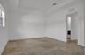 Neutral-toned tile flooring, recessed tray ceiling with crown molding, and a multi-panel door