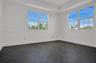 Room featuring dark wood-finish flooring in a herringbone pattern, a tray ceiling, and multi-pane windows