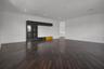 Spacious interior featuring dark wood-finish flooring, recessed lighting, crown molding, and built-in cabinetry with glass-front storage