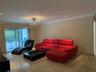 Polished stone tile flooring, crown molding, recessed ceiling lighting, and a decorative chandelier