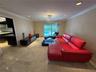 Recessed lighting, crown molding, and a crystal chandelier illuminate the interior