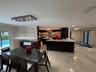 Open-concept living space with large format tile flooring and recessed lighting