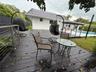 Expansive wooden deck with cable railings and a tiled roof structure