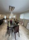 Recessed lighting, two distinct ceiling light fixtures, large format tile flooring, and multiple windows with blinds