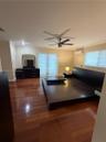 Wood-finish flooring, dual ceiling fans, recessed lighting, and wall-mounted air conditioning unit