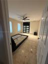 Polished tile flooring, recessed ceiling lighting, ceiling fan with integrated light, and a modern paneled door