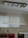 Rectangular chrome ceiling light fixture with multiple integrated downlights and cascading crystal elements