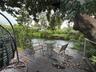 Wood-finish decking with a cable railing system, overlooking a natural water feature