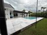 Outdoor swimming pool with a surrounding paved patio and a covered outdoor living area