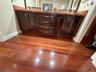 Dual vanity with a stone countertop, dark wood-finish cabinetry, and wood-finish flooring