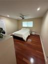 Hardwood flooring, recessed lighting, ceiling fan, louvered door, window with privacy blind