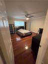 Hardwood flooring, crown molding, ceiling fan with integrated lighting, and neutral wall paint