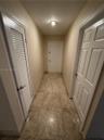 Hallway featuring square tile flooring, neutral wall tones, and recessed ceiling lighting